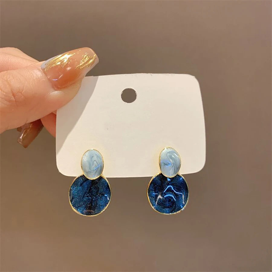 Pendantes émaillées bleues ovale et rond, en main